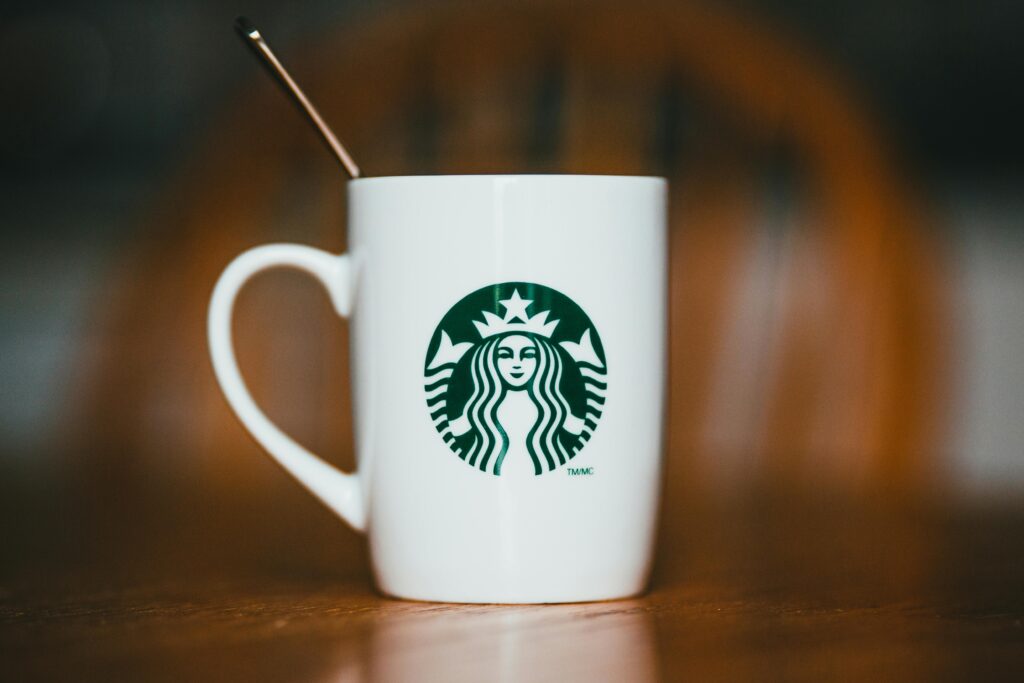 Mug of hot drink with Starbucks logo on wooden table